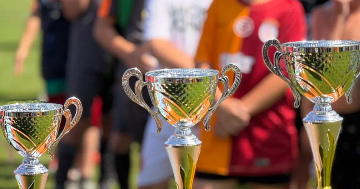 Pokale vor Teilnehmenden des CurveDesign Cup 2025.